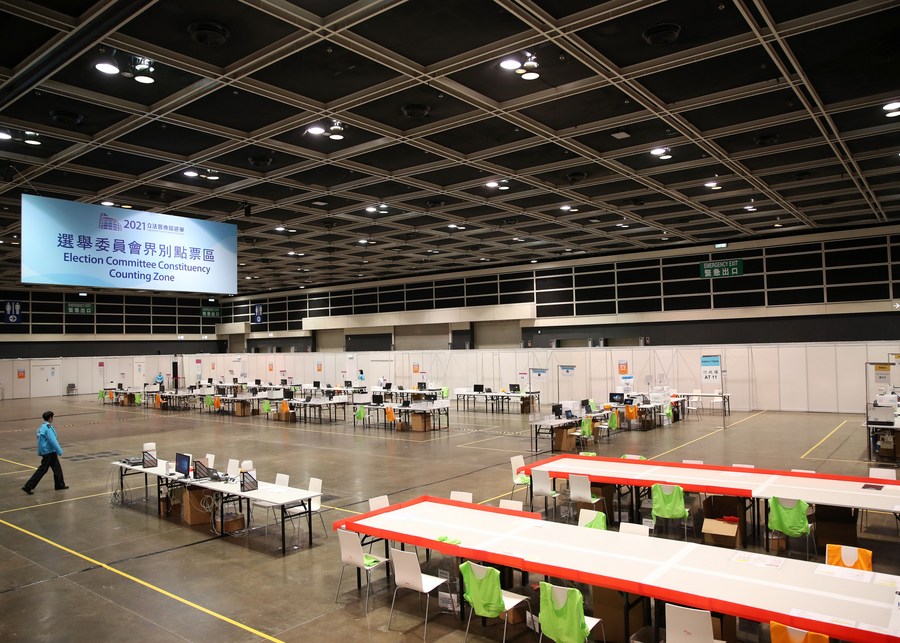 Staff members are seen at the counting station of the Hong Kong Convention and Exhibition Center in Hong Kong, south China, Dec. 19, 2021. / Xinhua/Li Gang