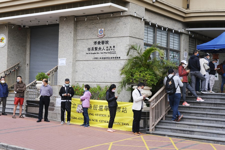 Voters wait to cast ballots at a polling station in Whampoa, Hong Kong, south China, Dec. 19, 2021. 