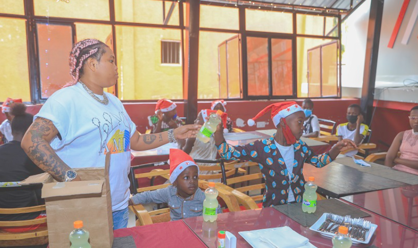 Briane giving kids drinks. / Courtesy