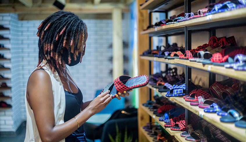 A customer looks at a Made in Rwanda womenu2019s  sandals at UZURI K&Y shoe shop at Kigali Heights. / Photo: Dan Nsengiyumva.