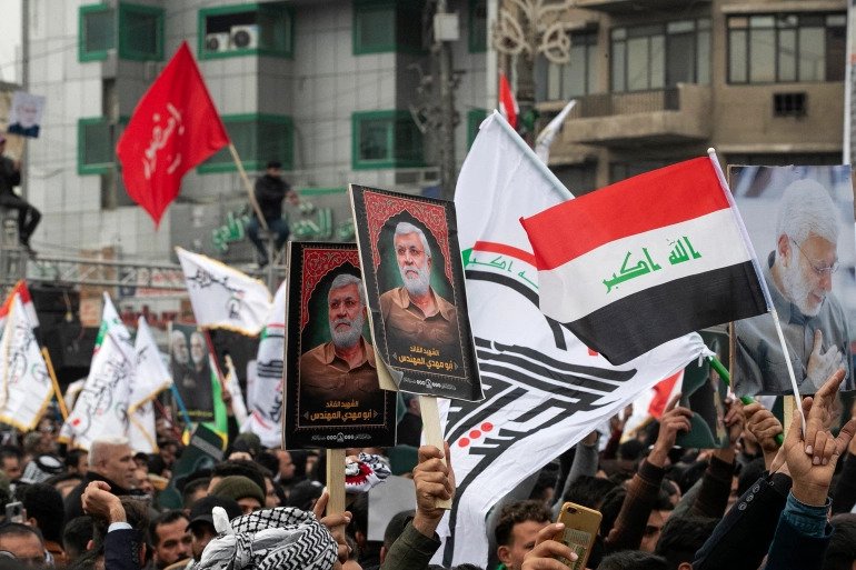 Supporters of al-Hashed al-Shaabi alliance take part in a symbolic funeral and commemoration of the second anniversary of the US raid that killed Qasem Soleimani and Abu Mahdi al-Muhandis, in Baghdad, on January 1, 2022. 