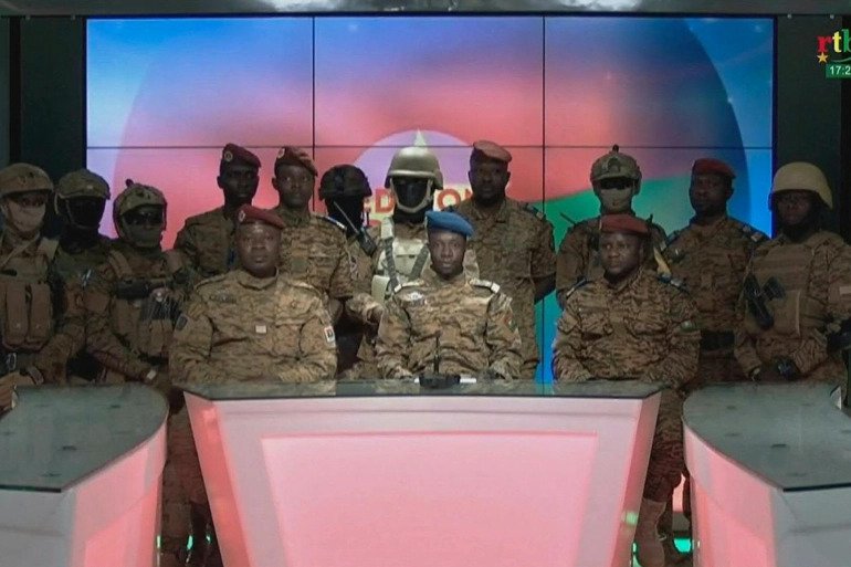 Captain Sidsore Kader Ouedraogo, centre, spokesman for the military government, with uniformed soldiers announces that they have taken power in Burkina Faso. 