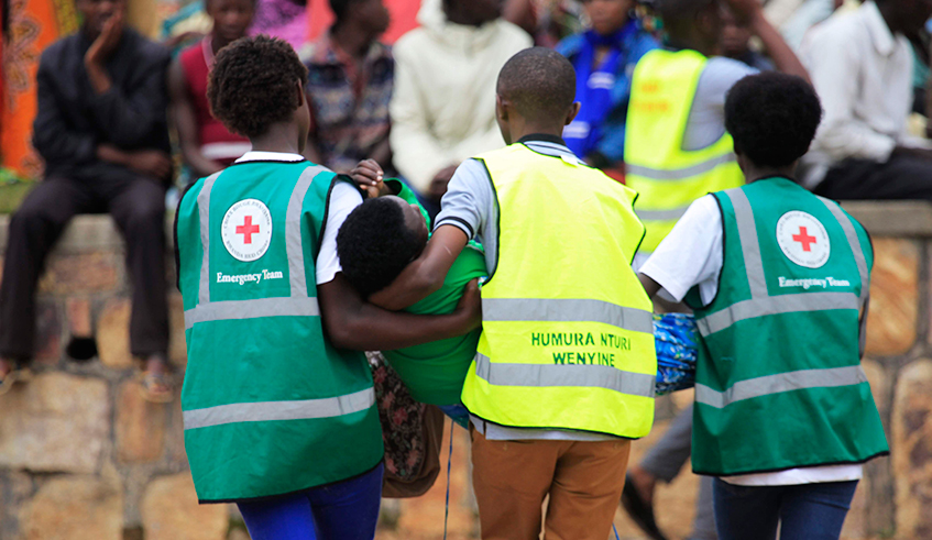 Volunteers carry a trauma victim during the commemoration event at Murambi Genocide Memorial . / File