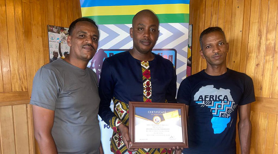 The national cycling federation president Abdallah Murenzi (center) poses with the UCI certificate with the owners of May cycling stars continental cycling club on Friday. Courtesy