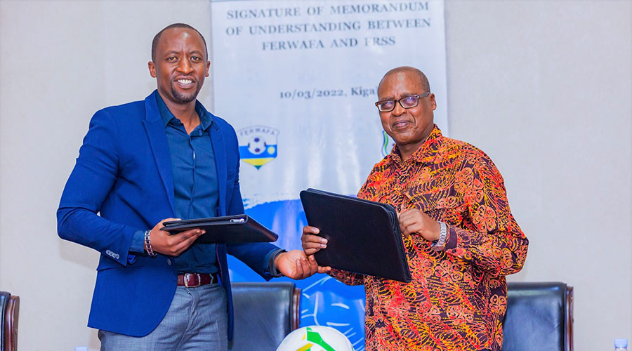 Ferwafa president Olivier Mugabo Nizeyimana  and Father Innocent Gatete, the head of Rwanda schools sports association after signing an MoU to develop and nurture young footballers in secondary schools across the country. 