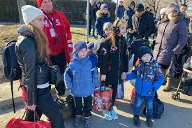Refugees cross the border from Ukraine to Poland, fleeing the Russian invasion of Ukraine, at a border checkpoint in Kroscienko, Poland,