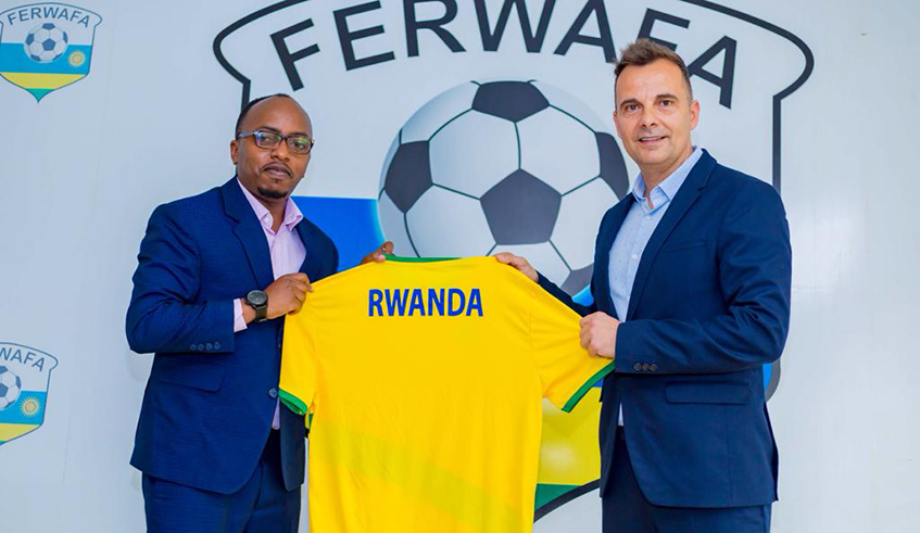 Ferwafa Secretary General Henry Muhire gives an Amavubi jersey to new coach Carlos Alos Ferrer after the latter signed a one year deal to coach the national team. Photo: Ferwafa.