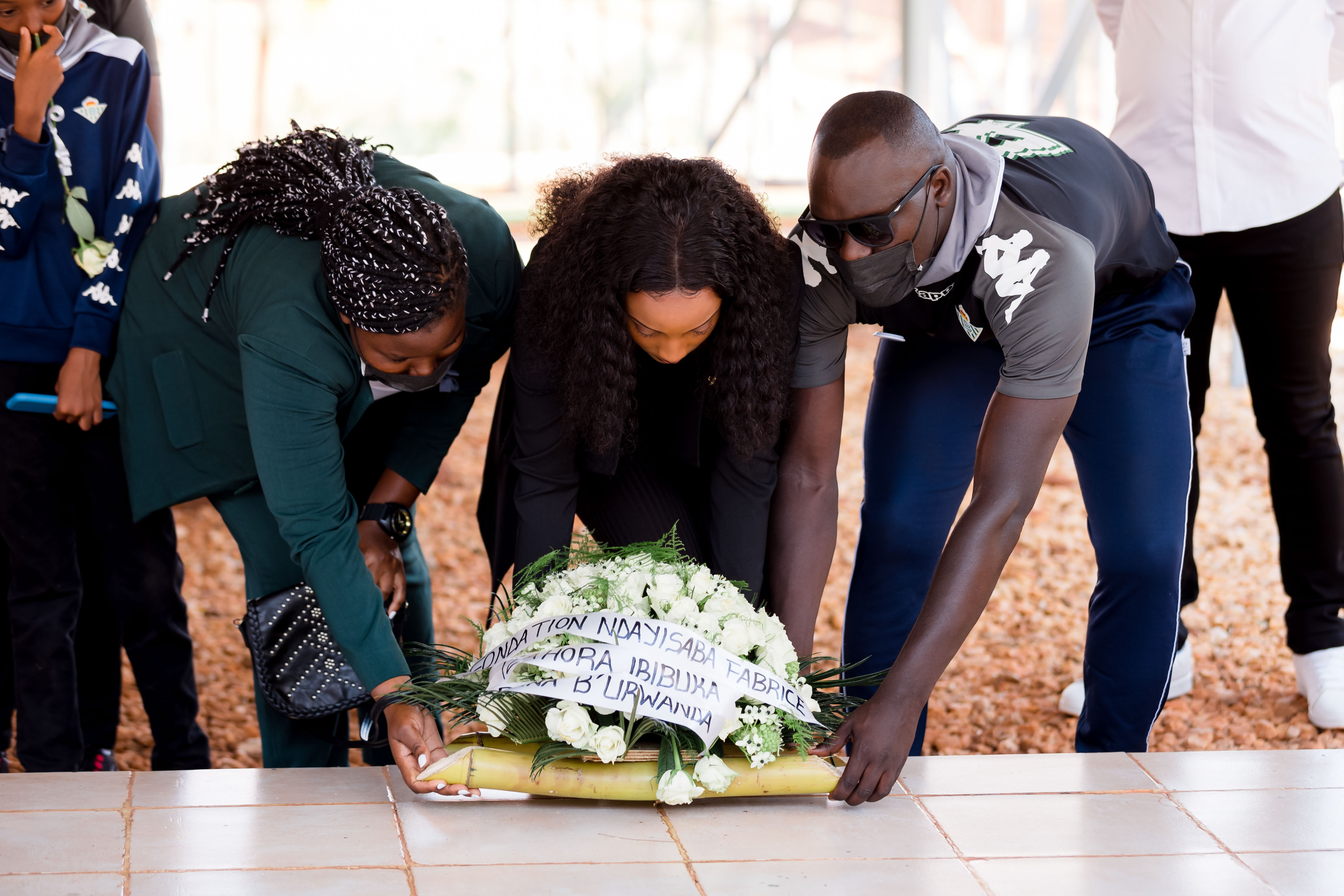 Divine Nshuti Muheto (centre) lays a wreath over the Nyanza Genocide Memorial grave where some kids were laid to rest. / Photos by Miss Rwanda