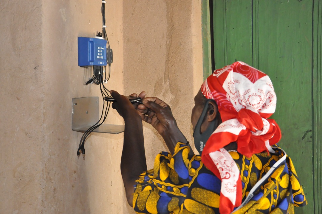 Immaculee Kasine recharges her phone with solar power. / Courtesy photos