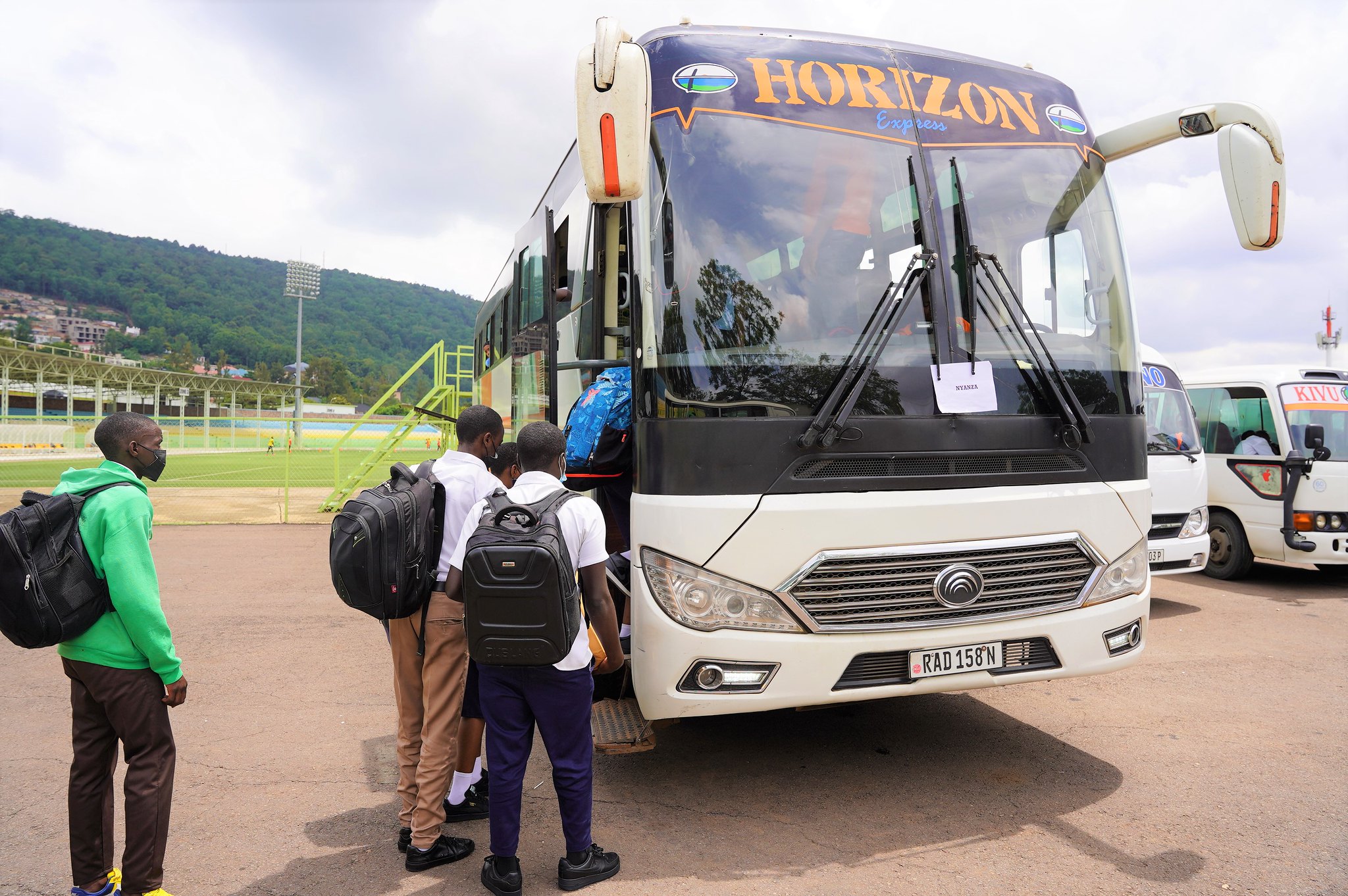 Students board a bus they go back to school for the third term at Kigali Stadium on April 18