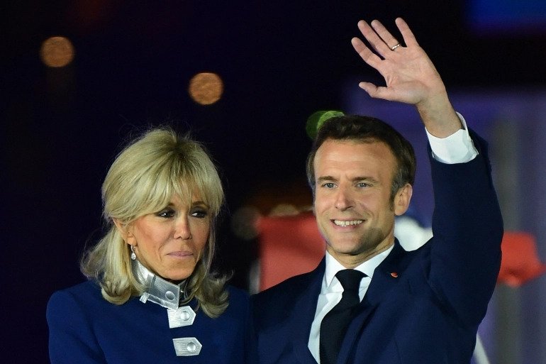 French President Emmanuel Macron and his wife Brigitte Macron celebrate after his victory in France's presidential election, at the Champ de Mars in Paris, on April 24, 2022. 
