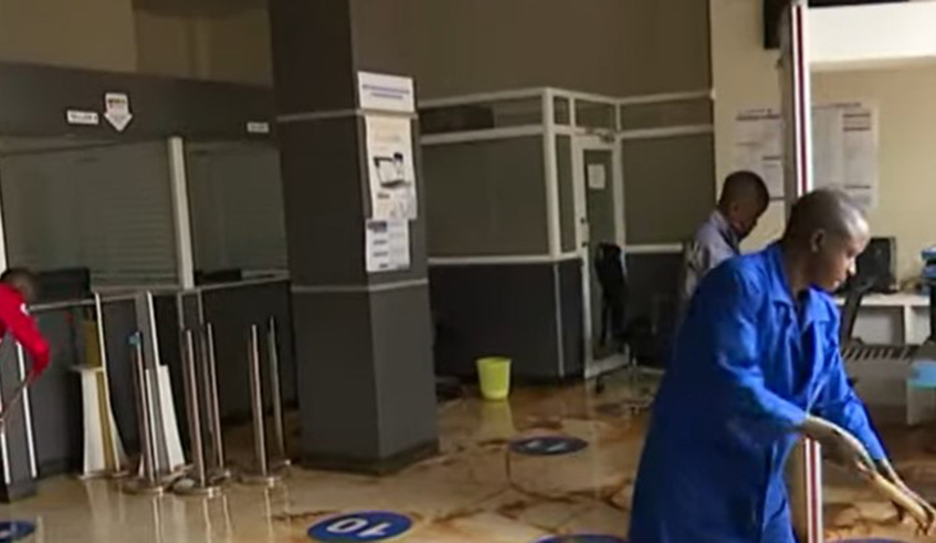 Workers clean inside one branch of the bank after heavy rains caused floods that damaged businesses at Kicukiro Centre. Courtesy