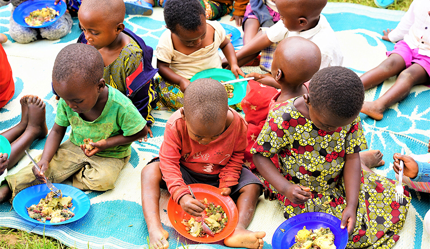 Children eat food prepared through a village program dubbed Igikoni cy'umuduguduu201d that was initiated to fight against malnutrition in Gakenke District. / Photos by Craish Bahizi