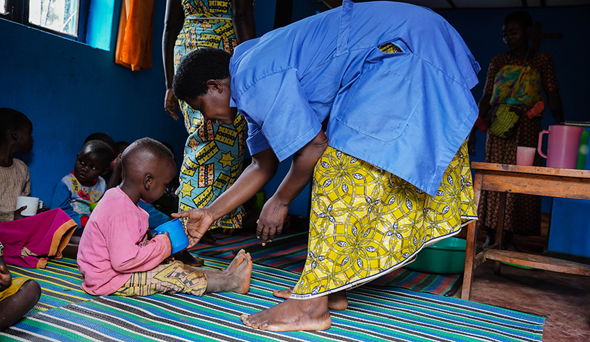 Emilienne Mushimiyimana serving porridge to Children at the ECD centres in Huye district.