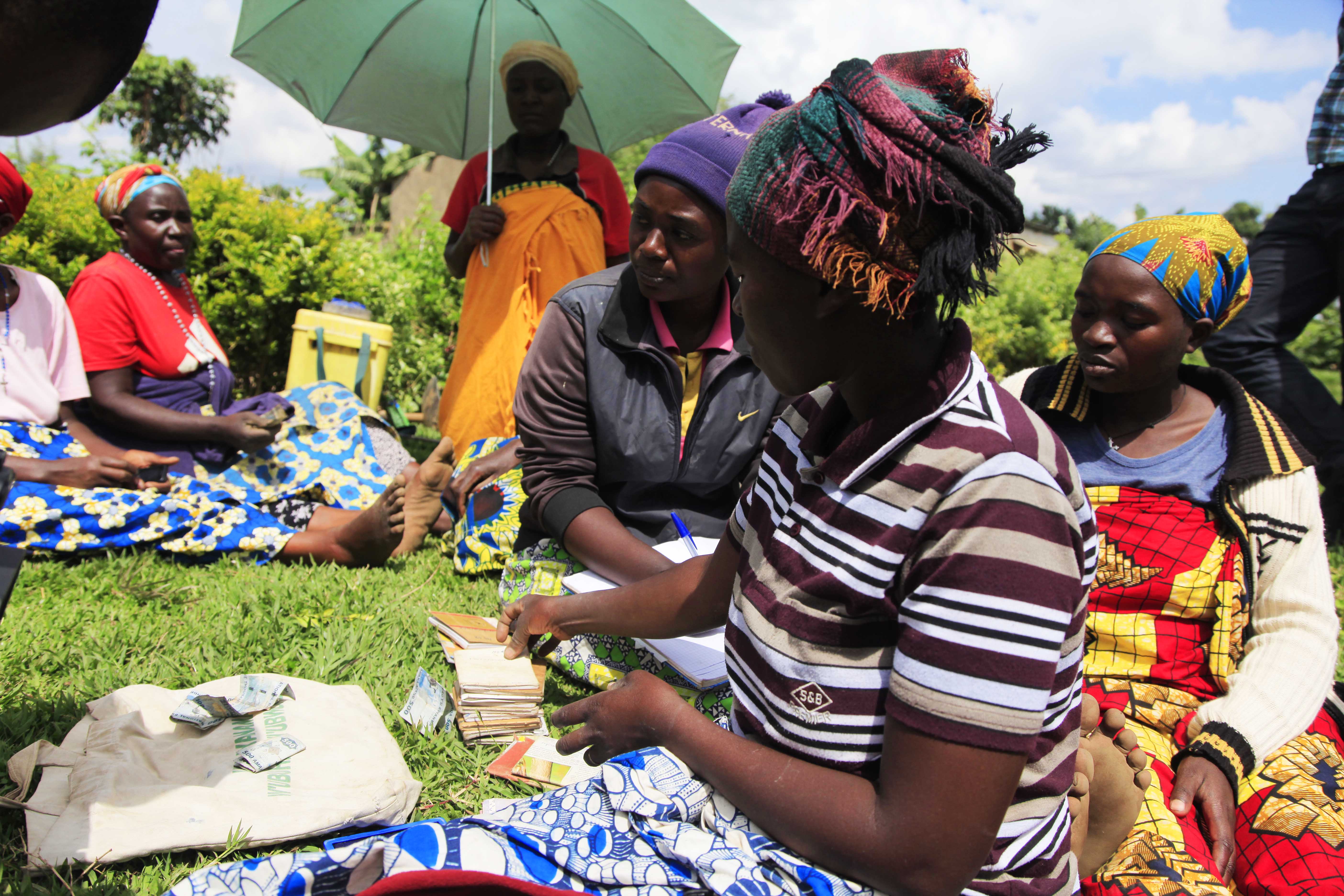Women collect weekly contrubution for saving and credit during a meeting of a cooperative in Muko Sector in Musanze District. Sam Ngendahimana