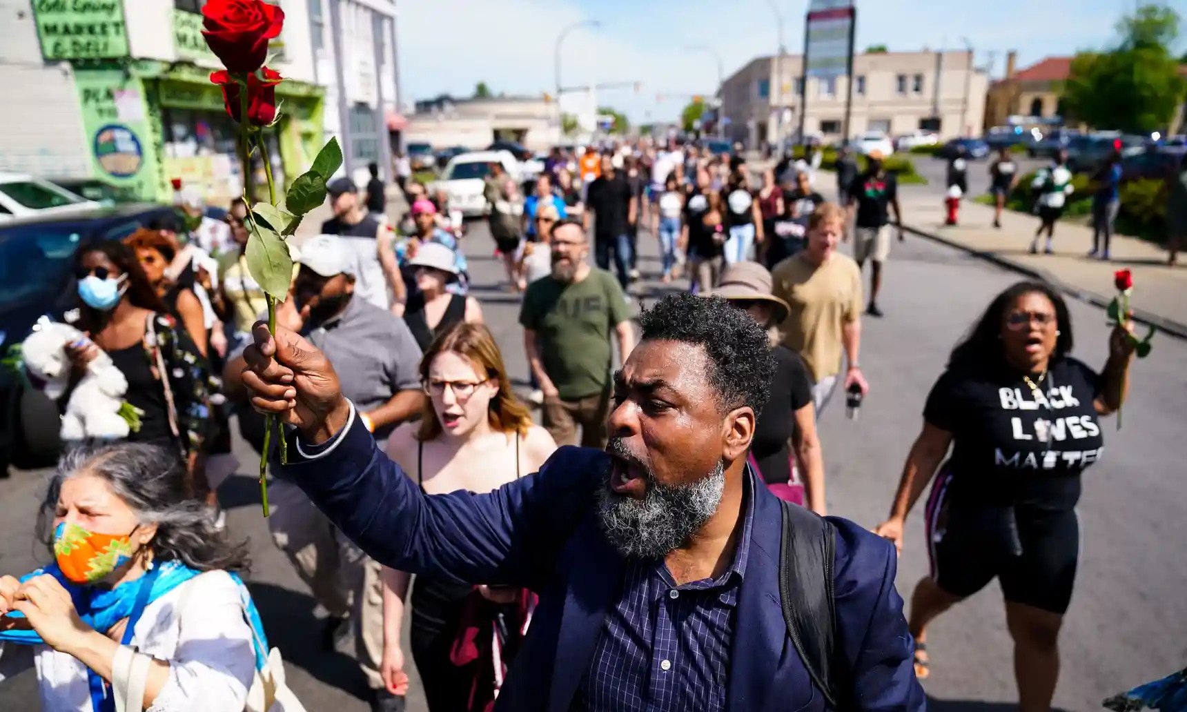 People march to the scene of a shooting at a supermarket in Buffalo, on Sunday. 