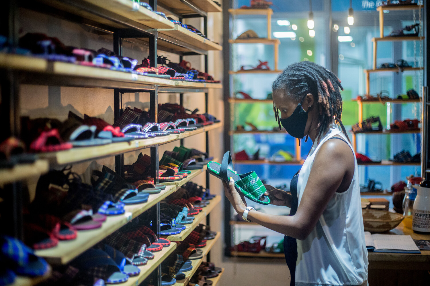A client tries UZURI Fashion shoes at Kigali Heights shop. 