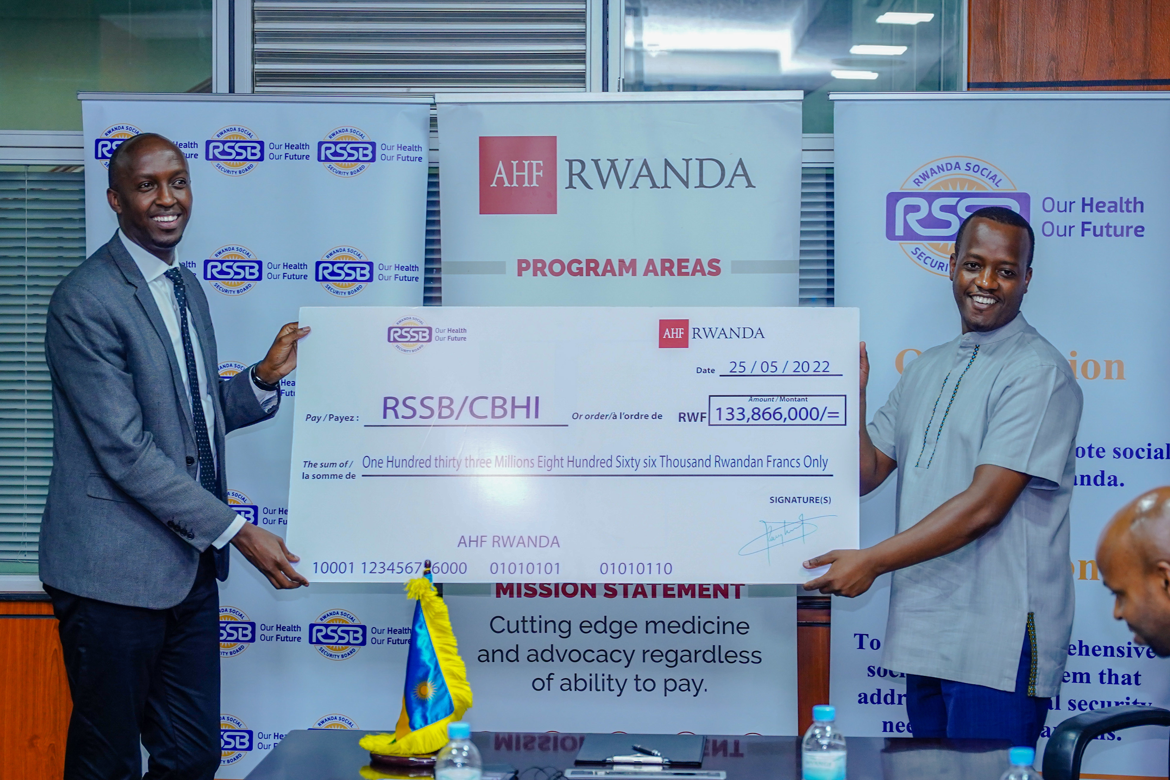 AHF Rwanda Country Program Manager  Lambert Rangira hands over the donation to RSSB Director General Regis Rugemanshuro to help vulnerable households afford the health insuarance in Kigali on May 25. Photo by Dan Nsengiyumva