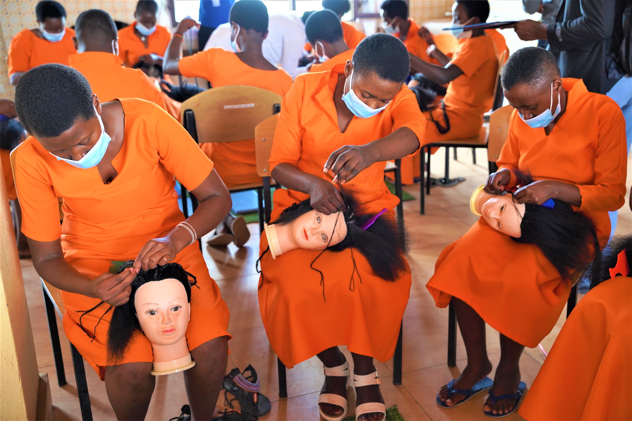 A trainer helps trainees during a hair dressing course at the Center