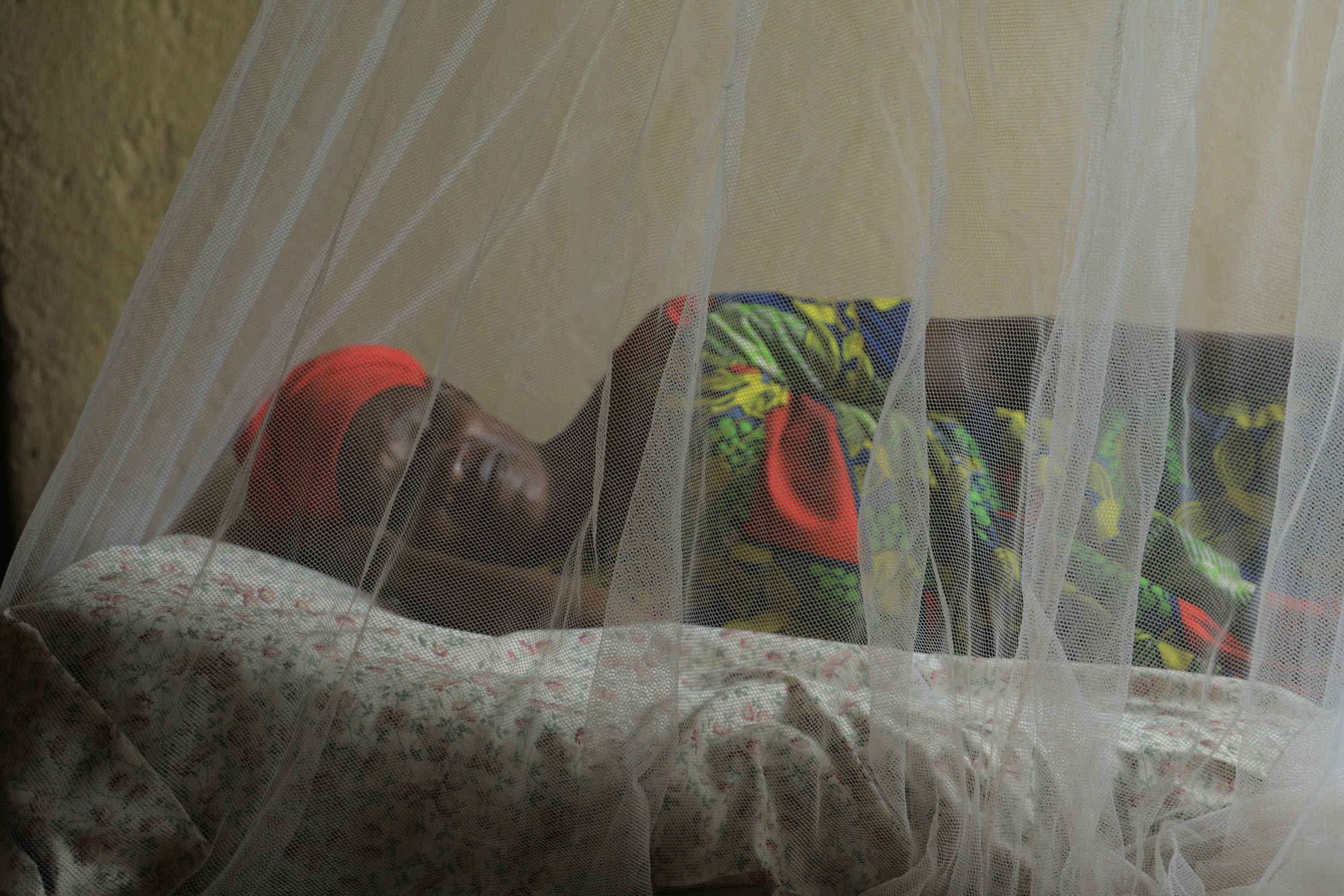 A woman sleeps under a mosquito net in Bugesera District. Statistics from Rwanda Biomedical Centre  show that the country recorded a drop in malaria incidence from 400 per 1,000 in 2016 to 89 per 1,000 in 2021. Photo: Dan Nsengiyumva.