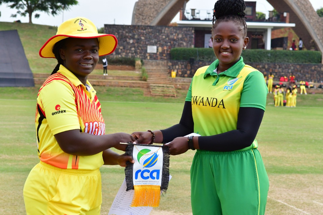 The Rwandan captain and her Ugandan counterpart exchange the teams' flags before the match at Gahanga Cricket Stadium on Thursday. 