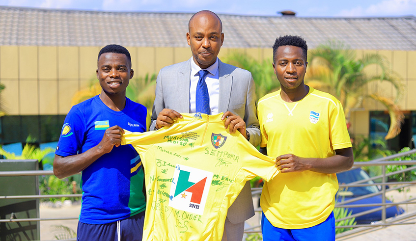 Abdallah Murenzi poses for a photo with Moise Mugisha and Didier Munyaneza who who Tour du Cameroun on Sunday. Murenzi was re-elected to be FERWACY President on June 11.Courtesy