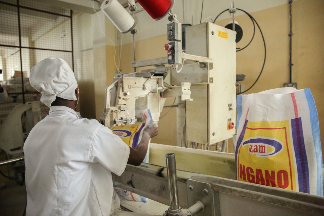 A worker seals wheat flour packages at Azam Industries in Kigali October 27, 2020. 
