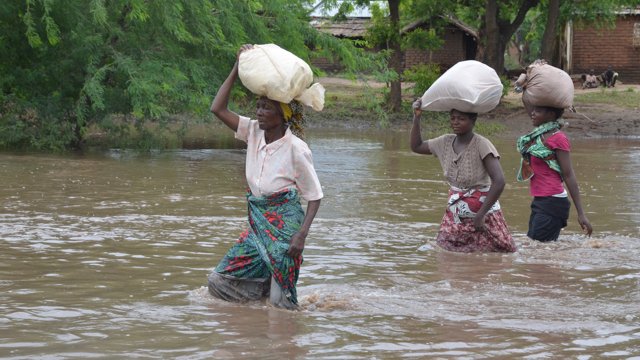 Malawi residents wade through a flooded road in Malawi. African Youth Conference on Climate Justiceu201d reiterated the need for including youth in climate change negotiations processes. Internet