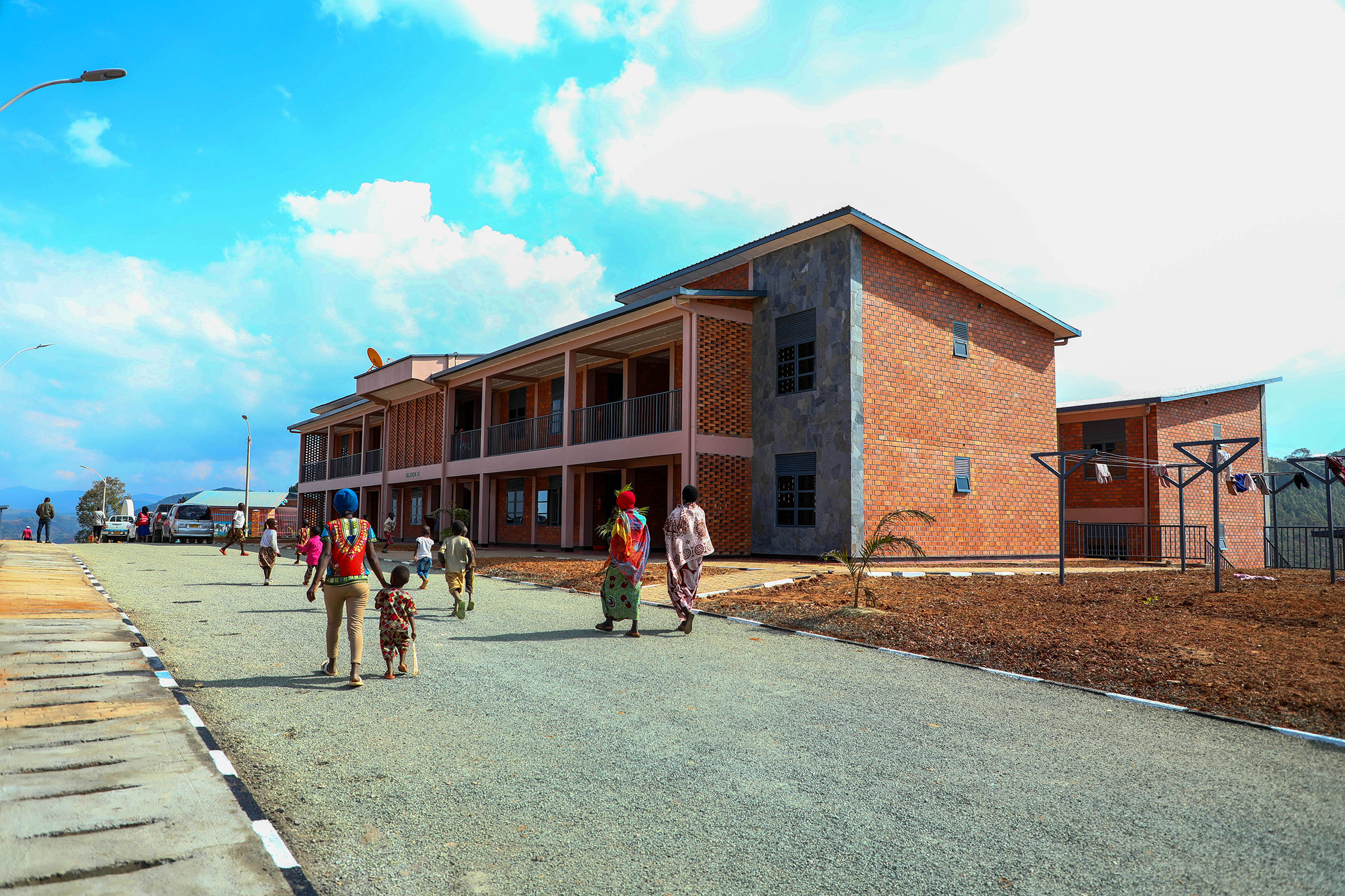 NEW HOME: Residents walk past one of the newly constructed Munini Integrated Model Village blocks in Nyaruguru District on Sunday, July 3. The model village, complete with fully-furnished self-contained homes for 48 vulnerable families, is one of the Rwf191 billion-worth of projects set to be inaugurated countrywide on the occasion of the 28th Liberation Day, on Monday, July 4. 