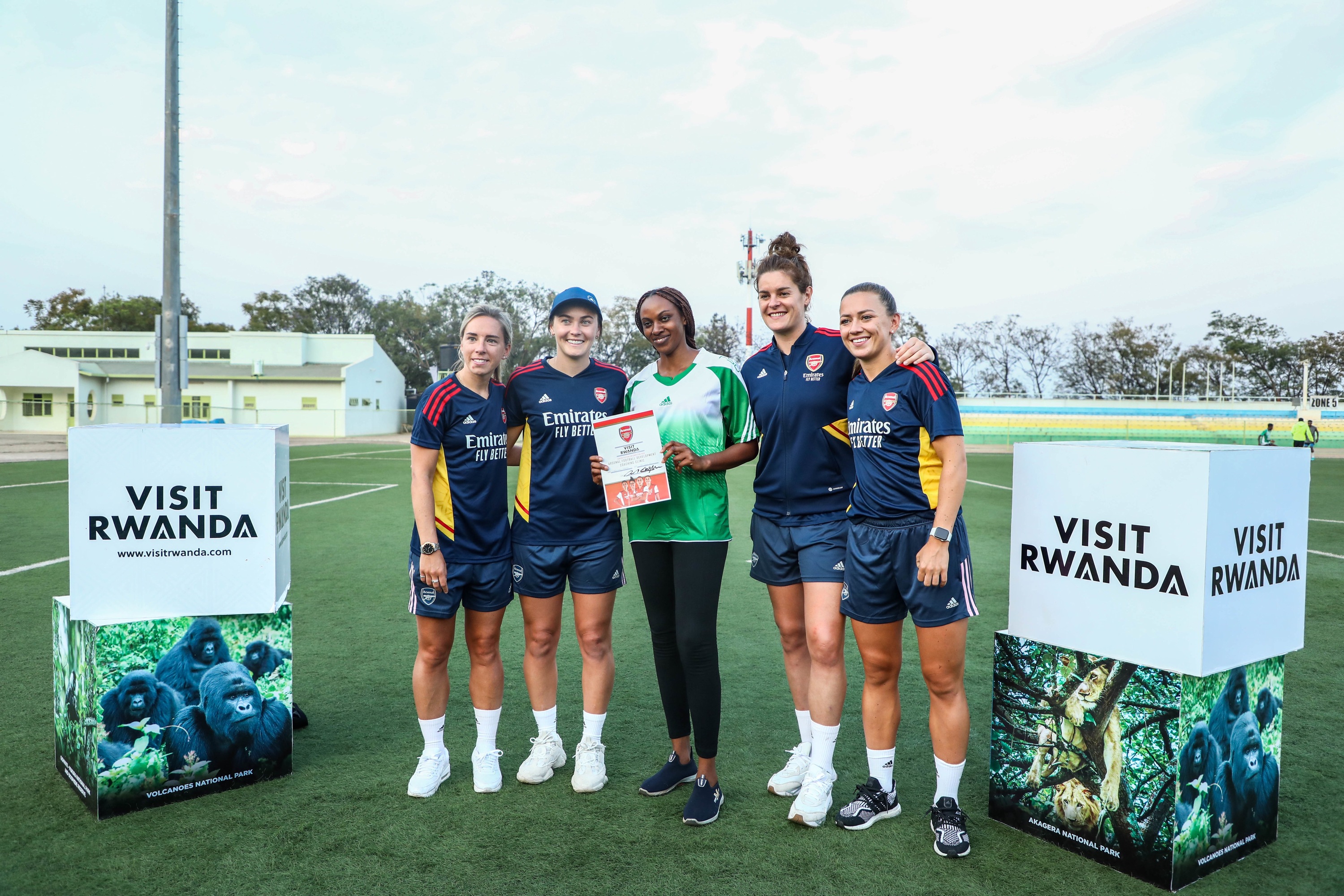 Arsenal women players handover a certificate of completion to one of the 25 participants at Kigali Stadium on Wednesday, July 6. / Dan Nsengiyumva