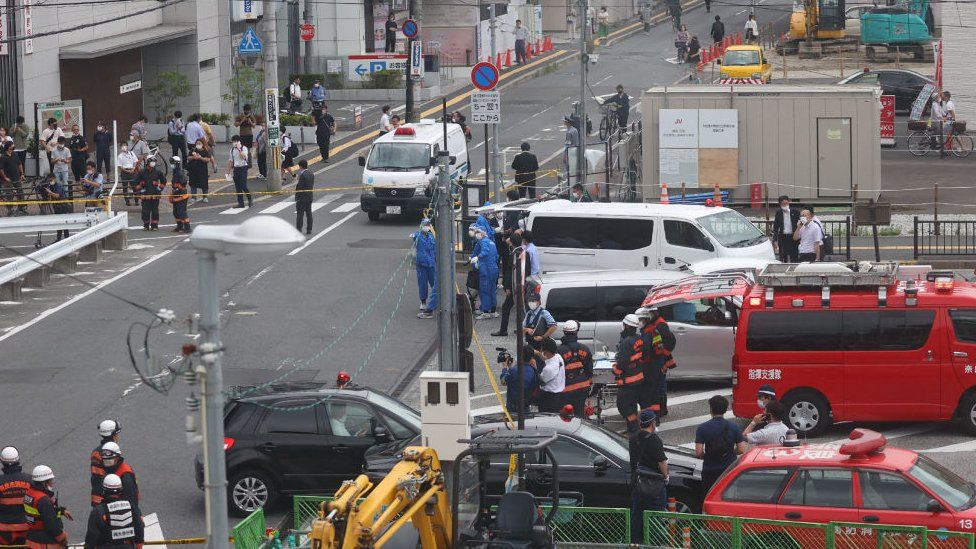 Workers at the scene after an attack on Mr Abe at Kintetsu Yamato-Saidaiji station square. 