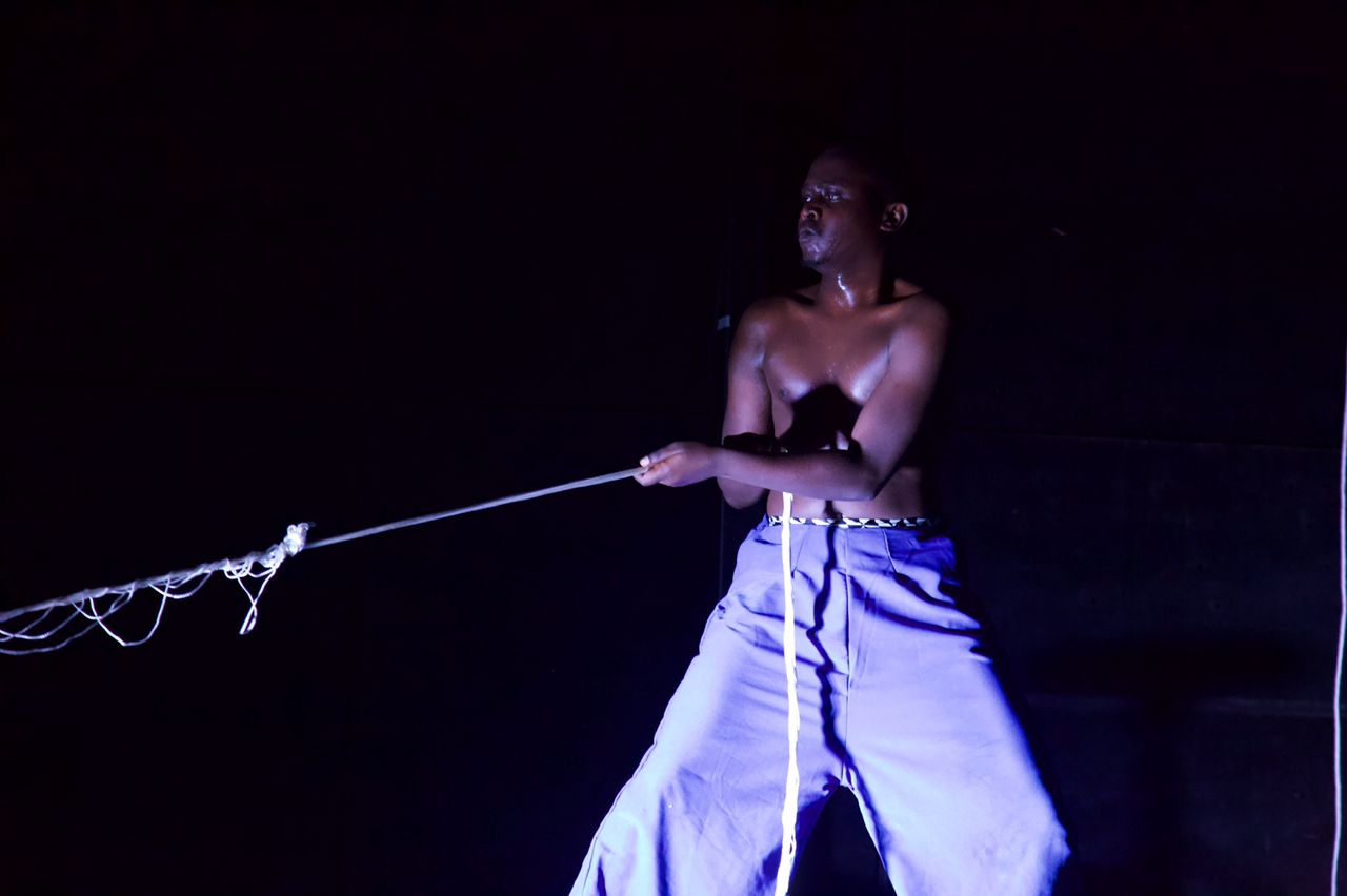 Isiaka Mbarushimana pulling a rope during his performance.
