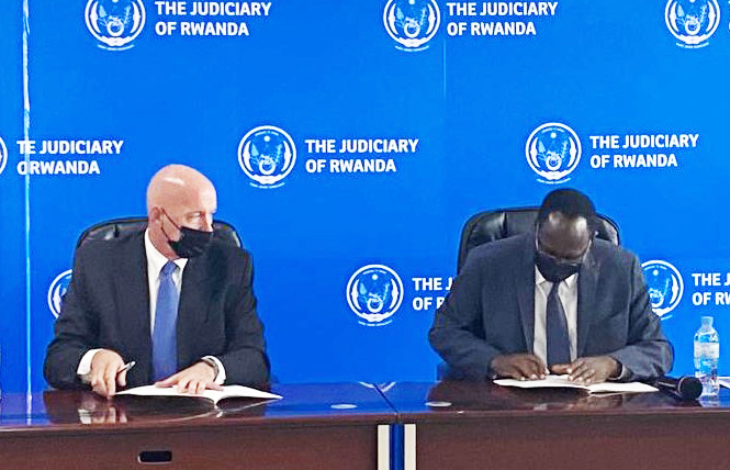 Faustin Ntezilyayo, the Chief Justice and Cameron McCollum on behalf of Pepperdine Caruso School of Law, sign the agreement in Kigali on August 10. Courtesy 